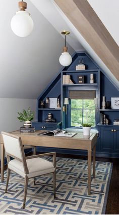 an attic office with blue painted walls and built - in shelving