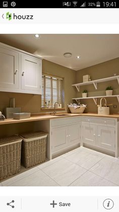 a clean kitchen with white cabinets and baskets on the counter top, along with two wicker bins