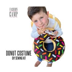 a young boy is holding a donut costume and posing for the camera with his mouth open