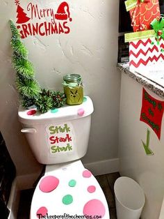 a toilet decorated for christmas with decorations on the tank lid and merry grinmas stickers