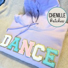 This Dance Sweatshirt, adorned with a unique dancer gift patch, is the perfect choice for a thoughtful Dance Mom or Dance Teacher gift. Stay cozy and stylish with this hooded pullover, designed to be an ideal Dance Team gift, showcasing your passion for dance in every step. PLEASE NOTE - Lilac color only available in adult size. - HEAVY WEIGHT HOODED SWEATSHIRTS - Gildan 18500 - Adult and Youth sweatshirts are made from polyester and cotton from the trusted Gildan brand. 🌟 Colors may appear slightly different in person versus on the computer screen and our photos all show natural lighting.  🌟 Patch pattern may be slightly different from what is shown (we alternate light pink, white, and aqua blue) letters for each order. Each order is custom made :)    🌟 The patches are heat pressed on Dance Mom Gifts, Dance Sweatshirt, Dance Team Gifts, Washing And Drying Machine, Patch Sweatshirt, Dance Teacher Gifts, Dancer Gift, Teacher Sweatshirt, Dance Mom