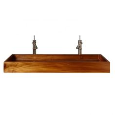 two metal faucets are mounted on a wooden shelf above a sink that is made out of wood