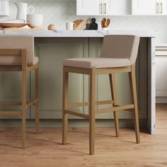 two beige bar stools sitting in front of a kitchen counter