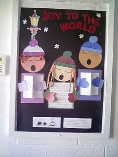 a bulletin board with paper cut out of children's faces and words that read joy to the world