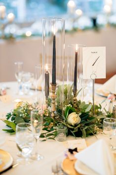 the table is set with candles, flowers and place cards for guests to sit at