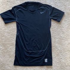 a black nike shirt laying on the floor