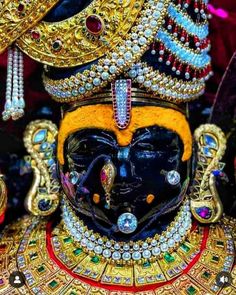 an elaborately decorated mask with jewels on it's face and headdress