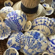 some blue and white shells sitting on top of a wicker basket