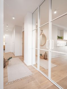 an empty room with white walls and wooden flooring is seen through large glass doors