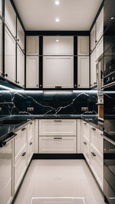 a kitchen with white cabinets and black counter tops in the center is lit by recessed lights