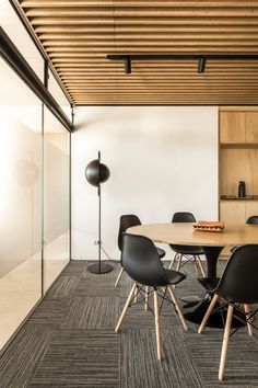 a table and chairs in a room with wood ceilinging on the walls, along with a lamp