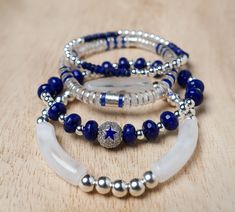 "Dallas Silver is a listing for 4 single bracelets or a stack of 4 this stack is absolutely gorgeous!  ** This game day stack features the following bracelets.** 1.  8mm blue rondelle jade, 4mm silver plated hematite beads, and 10mm enamel blue star bead. 2. 4mm silver plated hematite bead, and 4mm lapis bead bracelet 3. 8mm white marble acrylic tube, silver brushed cylinder, and  6mm silver brushed flat disc. 4. 4mm clear acrylic heishi bead, silver brushed flat disc, and 6mm brushed silver cyl Dallas Cowboys Beaded Bracelet, Dallas Cowboys Seed Bead Bracelets, Dallas Cowboys Bracelets, Dallas Cowboy Bracelet, Cowboys Helmet, Acrylic Tube, Women Bracelets, Trendy Bracelets, Fitness Bracelet