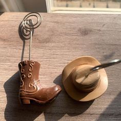 a pair of cowboy boots sitting next to a hat on top of a wooden table