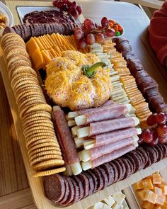 an assortment of cheeses, crackers, and meats on a platter