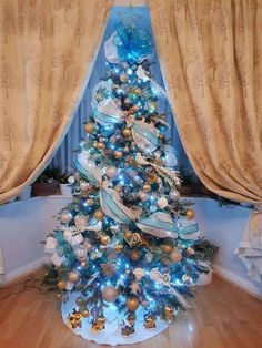 a decorated christmas tree with blue and gold ornaments