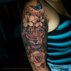 a woman's arm with a lion and flowers tattoo on her left arm, next to a butterfly