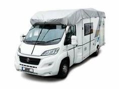 an rv with a cover on it is parked in front of a white background,