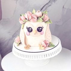 an owl cake with pink flowers on top