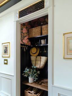 an open closet with baskets and hats on the shelf next to it is filled with potted plants