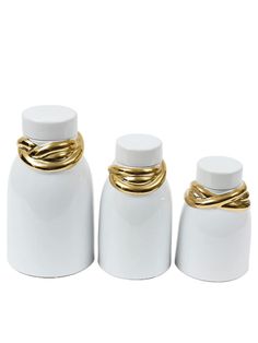 three white jars with gold rings on them