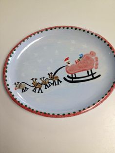 a plate decorated with santa's sleigh and reindeers on the side