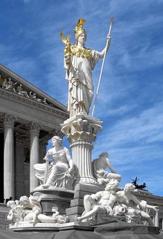 the statue is in front of an old building with columns and pillars on either side