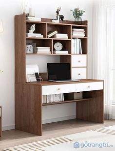 a computer desk with a laptop on top of it in front of a window and bookshelf