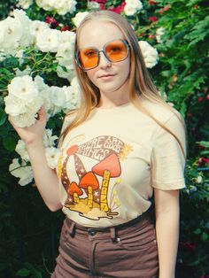 70s mushroom tee womens graphic tees vintage style 70s retro psychedelic tshirt women's hippy graphic tee hippy tshirt mushroom 60s shirt Our There Are Good Things in The World tee features a dreamy vintage-style print in mellow rusty hues. Size Guide: Our 100% cotton There Are Good Things in The World tee comes in a Unisex style on Soft Cream. Please refer to the provided tee measurements given in the listing images. It is advisable to compare these with the measurements of your favorite tee wh Summer Short Sleeve Tops With Mushroom Print, Summer Tops With Mushroom Print In Relaxed Fit, Summer Mushroom Print Relaxed Fit Top, Spring Mushroom Print Relaxed Fit Top, Summer Graphic Tee With Mushroom Design, Casual Summer T-shirt With Mushroom Design, Spring Crew Neck T-shirt With Mushroom Print, Groovy Summer T-shirt With Screen Print, Spring Mushroom Print Short Sleeve T-shirt