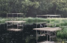 three wooden platforms floating on top of a lake