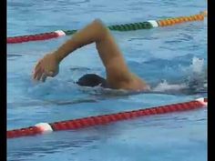 a woman swimming in a pool with red and green markers on the side of her body