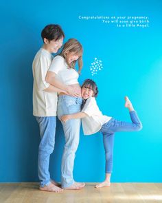 three people standing in front of a blue wall