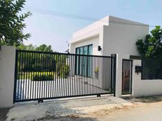 a white house with black iron fence and gate