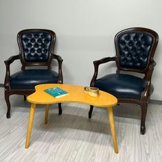 two chairs and a table with a book on it