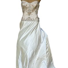 a white dress with gold sequins on the top and bottom, sitting on a mannequin