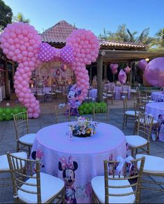 a minnie mouse themed birthday party with pink balloons and mickey mouse decorations on the tables