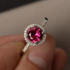 This is a gorgeous handmade creation. Its beauty is its simplicity & Elegance. The 7*7mm round cut lab created ruby is crafted in solid sterling silver and with rhodium plated. All item is sent in a beautiful gift box You can realize more lovely stuff clicking the link https://www.etsy.com/shop/knightjewelry?refshopsection_shophome_leftnav Please leave the correct address and you phone number for delivering successfully. 14k White Gold Ruby Ring With Halo Setting, Ruby Halo Ring For Promise Occasion, Ruby Halo Promise Ring, Classic Round Crystal Birthstone Ring, Formal Ruby Ring With Cubic Zirconia In Round Band, Ruby Ring With Halo Design In Round Cut, Lab-created Ruby Halo Ring For Promise, Lab-created Ruby Halo Ring For Anniversary, Ruby Ring With Halo Design And Round Cut