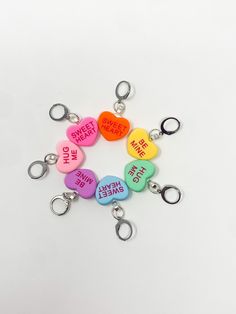 six heart shaped key chains with words on them