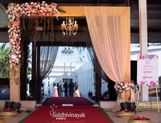 a red carpet with pink flowers on it in front of a stage and chandelier