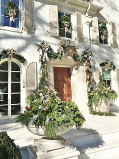 a large white building with lots of windows and plants on the side of it's wall