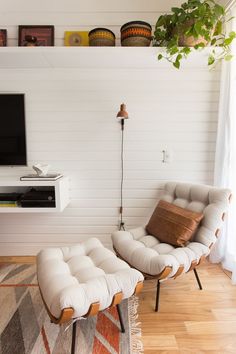 a living room with two chairs and a television