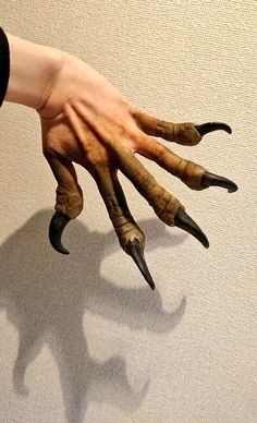 a person's hand with fake nails and claws on it, against a white background