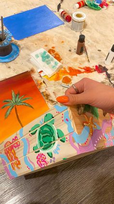 a person is painting on a wooden table