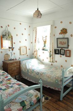 two twin beds in a bedroom with polka dot wallpaper on the walls and wooden floors