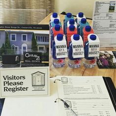 several bottled water bottles sitting on top of a wooden table next to papers and paperwork