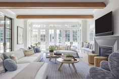 a living room filled with furniture and a flat screen tv mounted on the wall over a fireplace