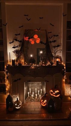 a fireplace decorated for halloween with candles and pumpkins