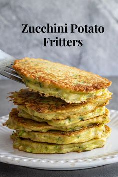 zucchini potato fritters on a white plate with a fork in it