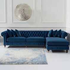 a blue couch sitting on top of a white floor next to a rug in a living room