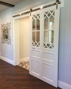 an empty room with white doors and wood floors