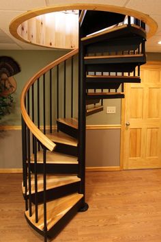 there is a spiral staircase in the middle of a room with wood floors and walls